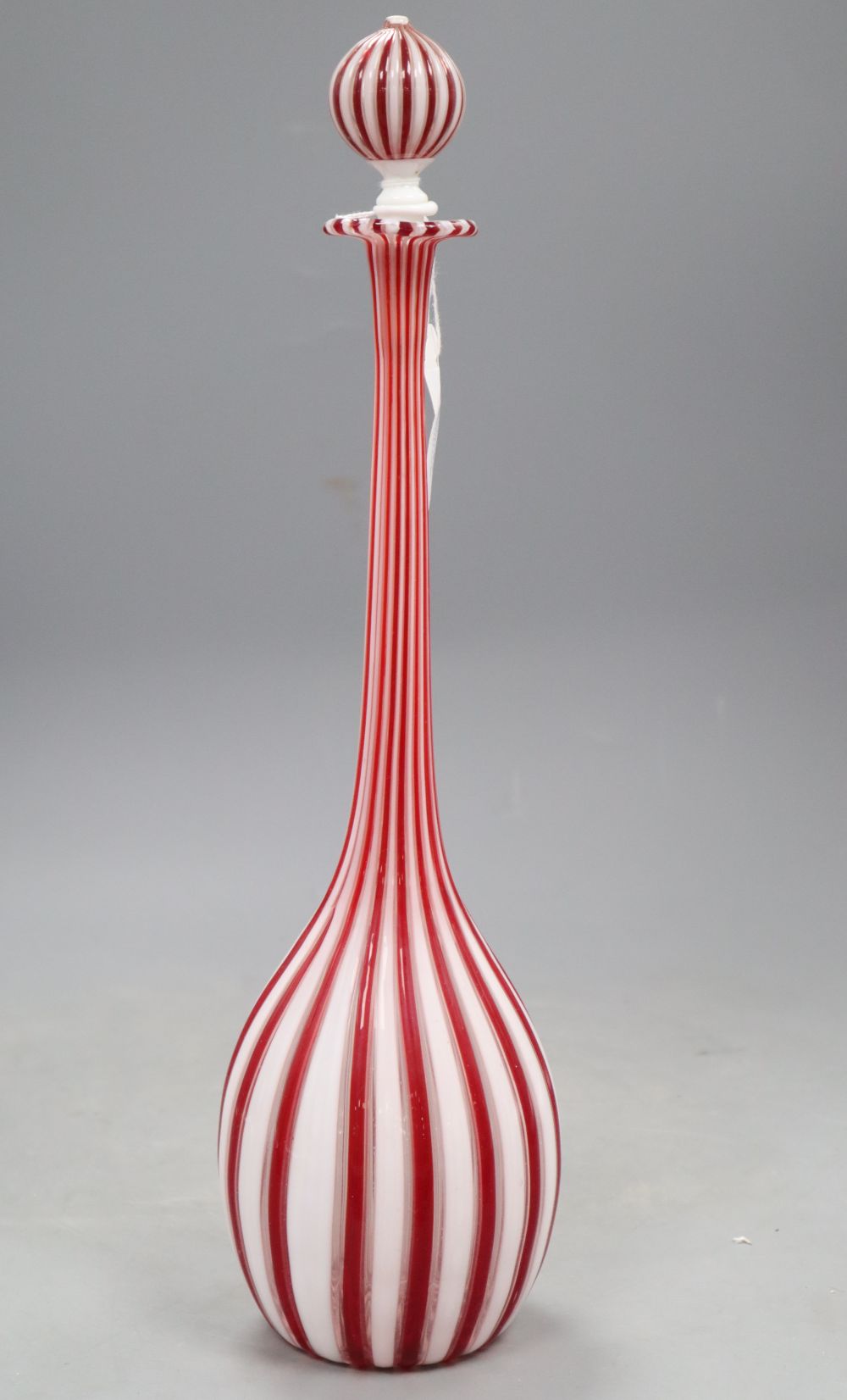 A slender Venetian red and white glass bottle and stopper